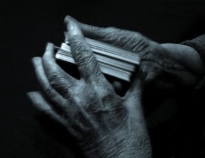 An image of the Hands of a mature aged lady shuffling the cards to play UNO with the grandkids.