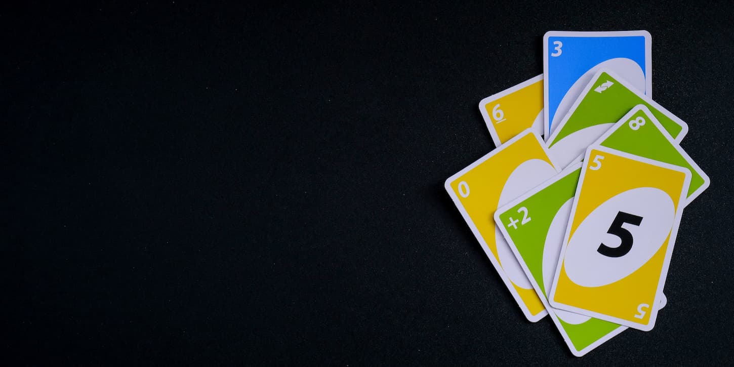 An image of Playing cards UNO on black Table games. Pastime. Board games. A stay-home leisure activity for kids.