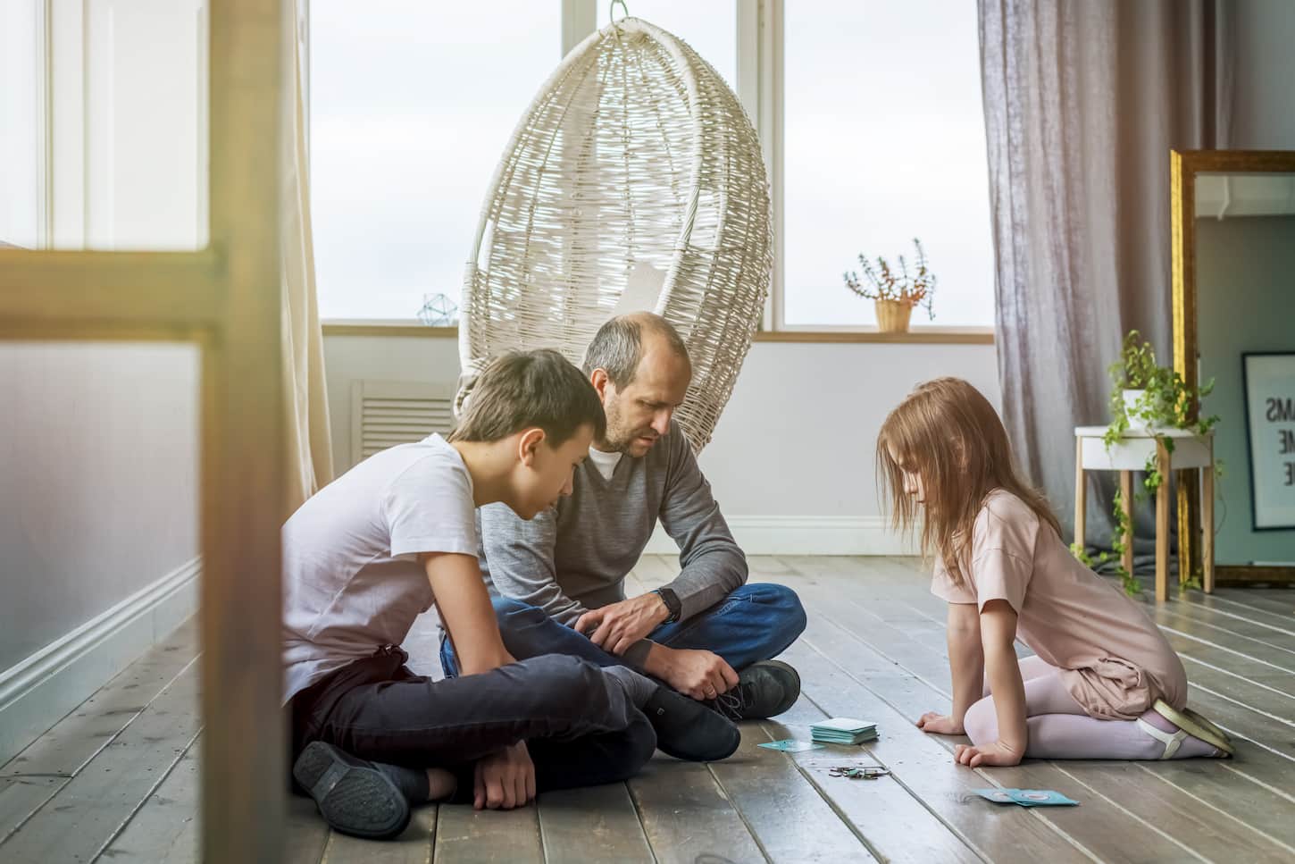 An image of children playing a board game with their dad. Game night.