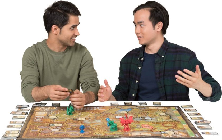 An image of two men sitting and arguing at a table while playing a game of monopoly.