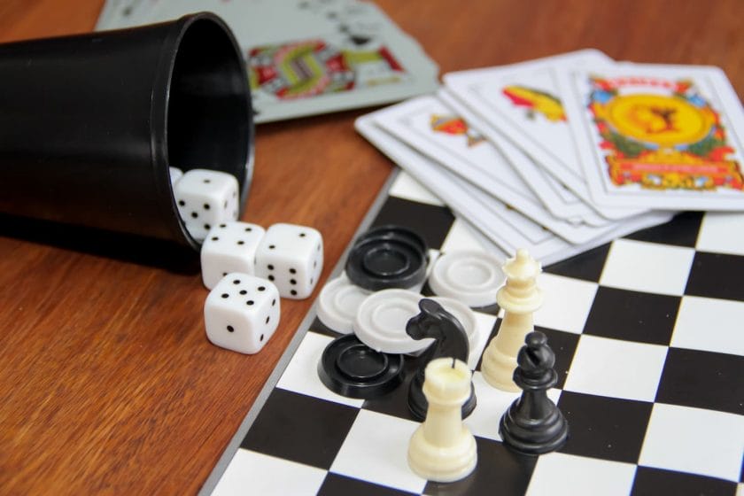 An image of a variety of goblet table games, dice, poker cards chess, and checkers.
