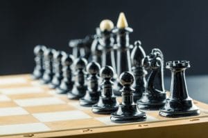 An image of Black chess figures on the board ready to be played.