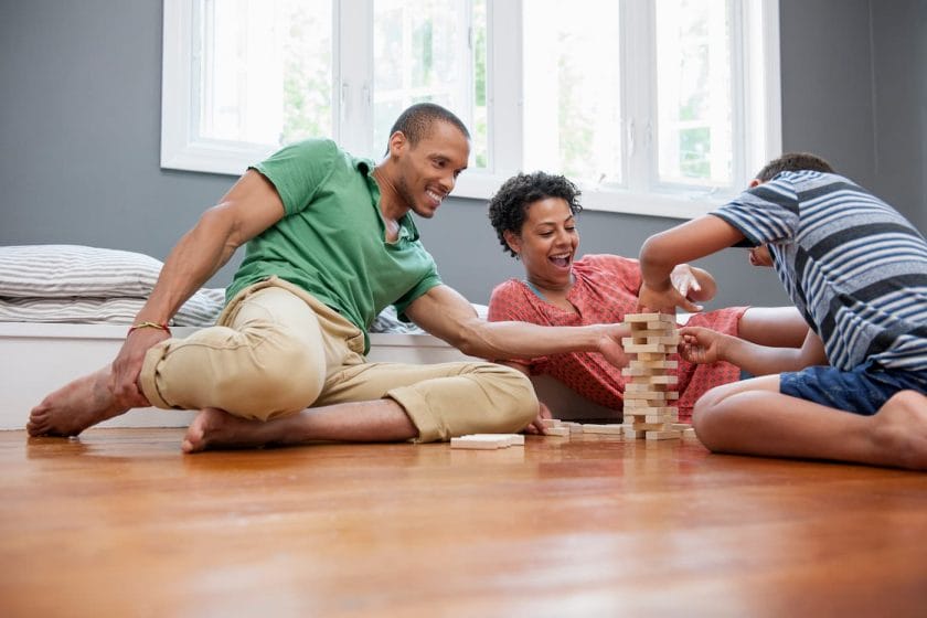 Image of a family playing Jenga on the floor.