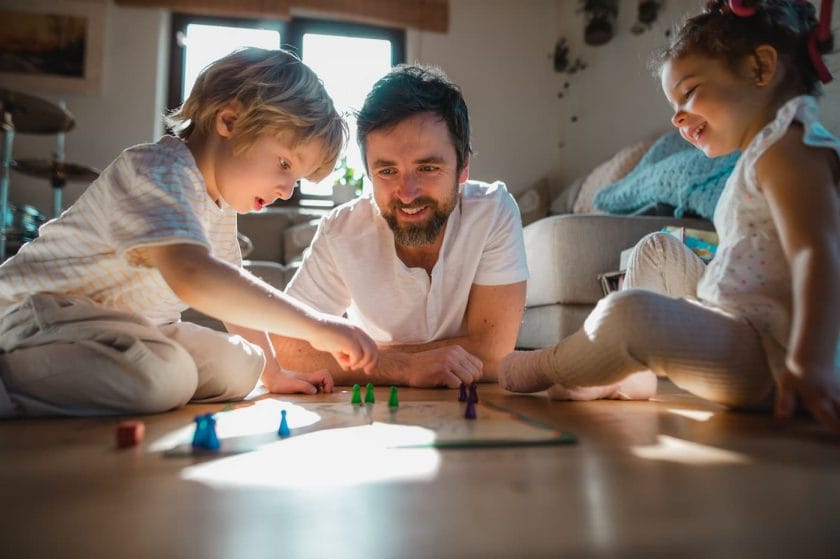 An image of a dad playing a game with children.
